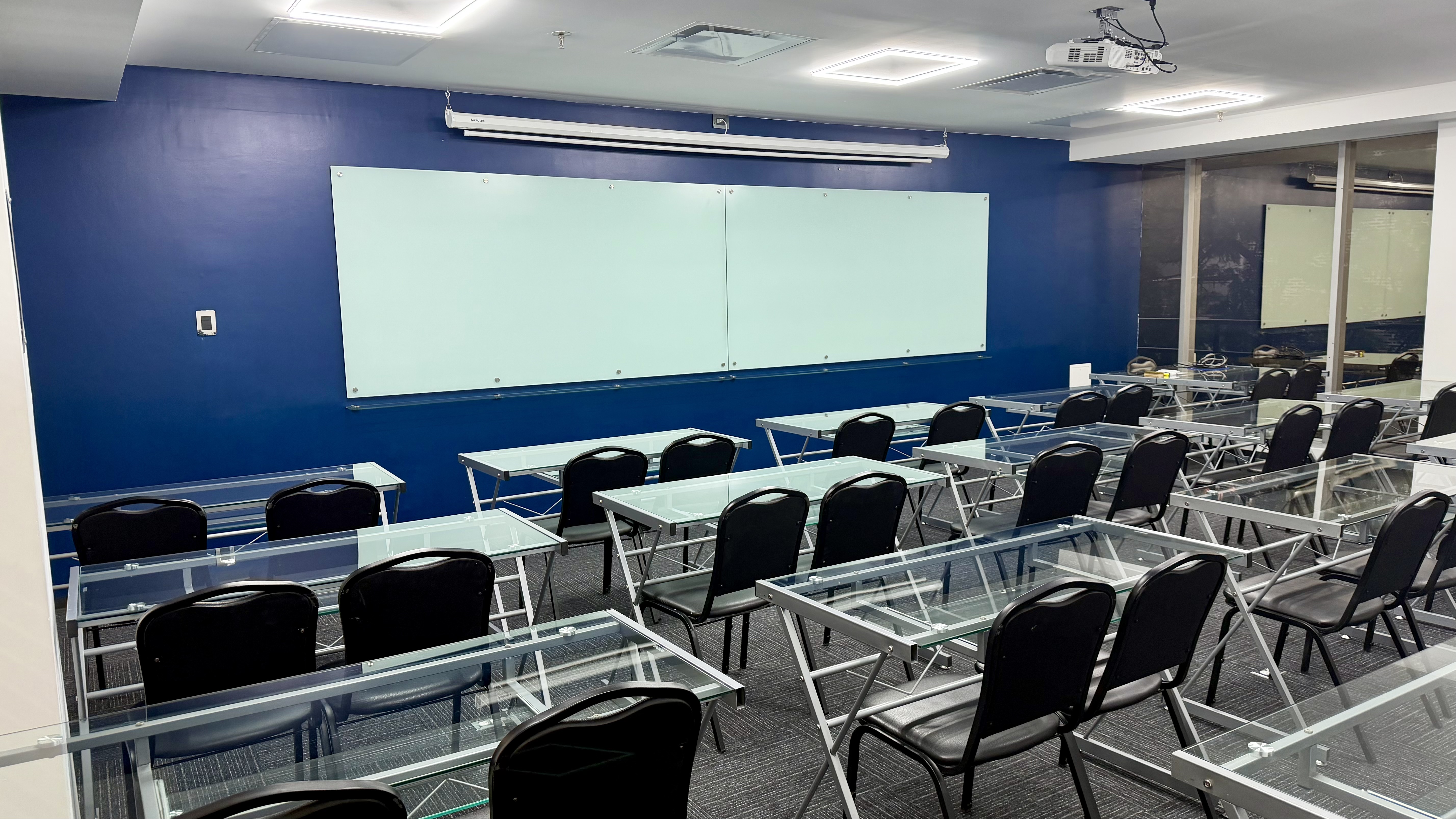 Aula de IMECAF con mesas de cristal, pizarrones y proyector